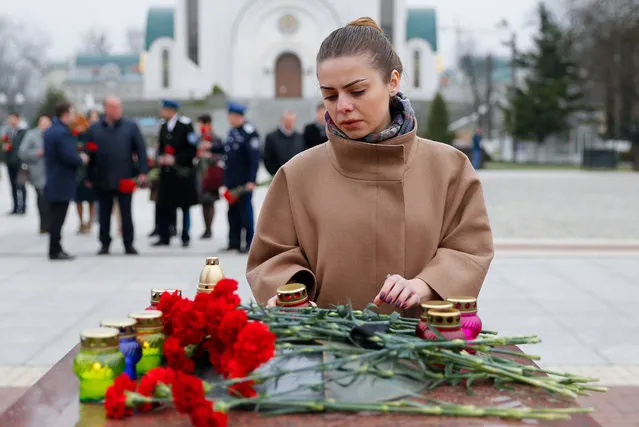 A woman leaves flowers in Podedy Square in memory of the St Petersburg metro explosion victims in Kaliningrad, Russia, Tuesday, April 4, 2017. (Photo by Vitaly Nevar/TASS)