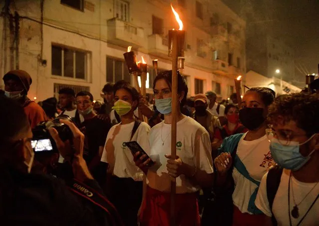 Young Cubans participate in the Torchlight March on the 169th anniversary of the birth of poet Jose Marti in Havana on January 27, 2022. (Photo by Yamil Lage/AFP Photo)