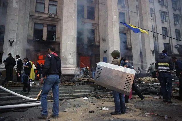 Protesters look at a fire in the trade union building in Odessa May 2, 2014. (Photo by Yevgeny Volokin/Reuters)