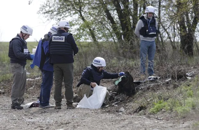 Members of the Organisation for Security and Cooperation in Europe work at the site of a recent incident, when an OSCE vehicle struck a mine, near the village of Pryshyb outside Luhansk, Ukraine, April 25, 2017. (Photo by Alexander Ermochenko/Reuters)