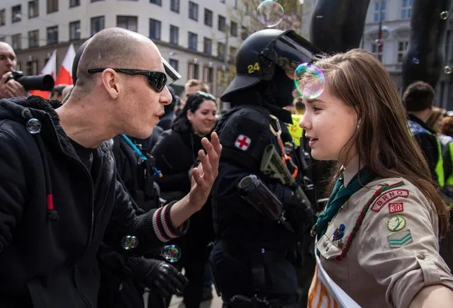 In this picture taken in Brno, Czech Republic, Monday, May 1, 2017, 16-year-old girl scout Lucie Myslikova talks to a protester at a right wing demonstration. The Czech teenager was among some 300 protesters who confronted a rally of the far right Workers Party of Social Justice on May Day in the second largest Czech city of Brno. (Photo by Vladimir Cicmanec/AP Photo)
