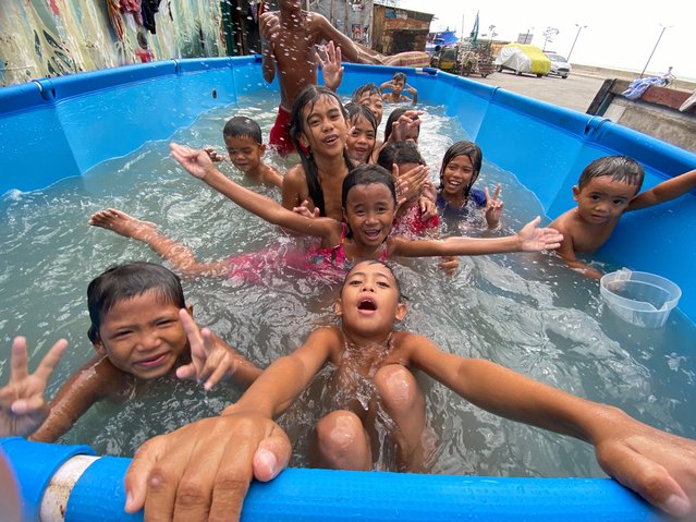 Filipino children frolic in a makeshift swimming pool along a street in Manila, Philippines, 08 May 2024. The Philippine state weather bureau said in its May 08 forecast that at least 18 areas across the country, including the Philippine capital Manila, could have a danger-level heat index in the range of 42 to 51 degrees Celsius. (Photo by Francis R Malasig/EPA/EFE)