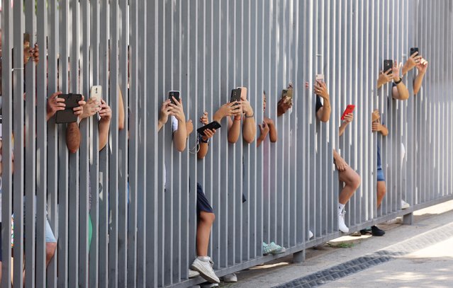 FC Barcelona fans take photos through a barrier outside the Camp Nou stadium as Sergi Roberto prepares to bid farewell to the club in Barcelona, Spain on August 13, 2024. (Photo by Nacho Doce/Reuters)