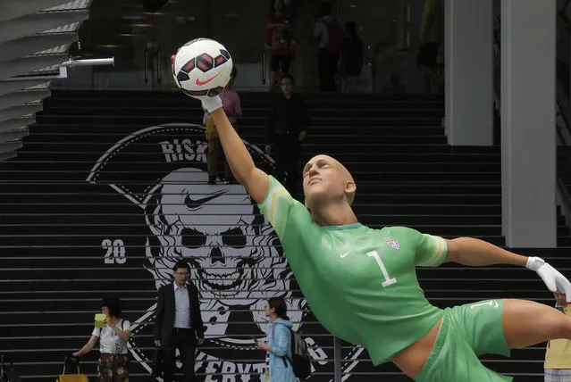 A giant size figure of the United States' goalkeeper Tim Howard is displayed outside a shopping mall in Hong Kong, Thursday, June 12, 2014, to promote the upcoming 2014 World Cup in Brazil. A total of seven 3.5 meters to 4 meters (11 feet 6 inch to 13 feet one inch) tall figures of famous players attract many soccer fans. (Photo by Vincent Yu/AP Photo)