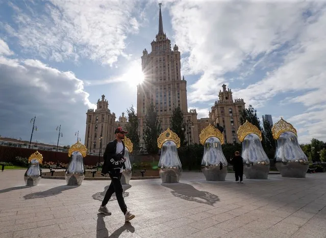 An art object, which consists of seven Russian traditional nesting dolls, also known as Matryoshka dolls, decorated with the traditional headwear Kokoshnik and mirrored surface, is on display near a Soviet-era landmark building in Moscow, Russia on September 10, 2021. (Photo by Evgenia Novozhenina/Reuters)