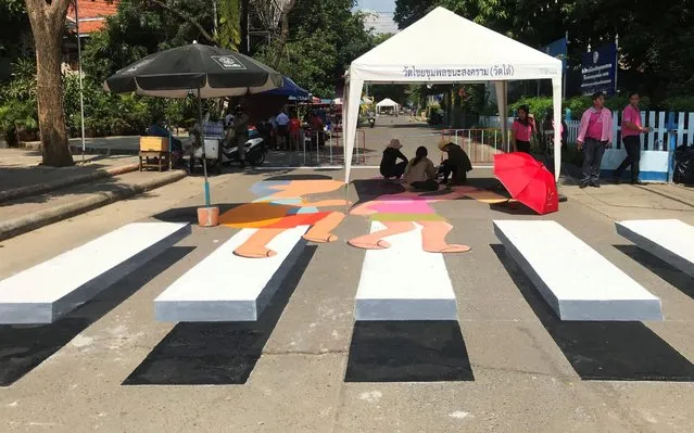 People paint a 3D pedestrian crossing in Kanchanaburi province, Thailand on October 25, 2019. (Photo by Prapan Chankaew/Reuters)