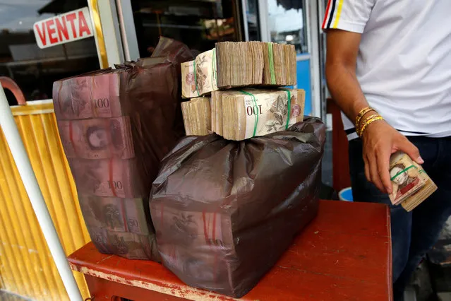 Plastic bags filled with Venezuelan bolivar notes are seen on a currency trader's table on a street in Puerto Santander, Colombia, June 3, 2016. (Photo by Carlos Garcia Rawlins/Reuters)