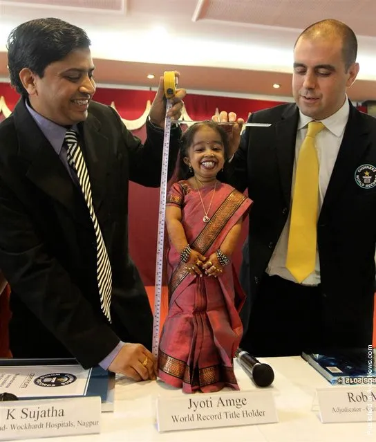 Guinness World Records adjudicator Rob Molloy (R) and Indian doctor K. Sujatha (L) measure the height of Jyoti Amge, the world's shortest living woman, on her 18th birthday in the central Indian city of Nagpur on Dec. 16