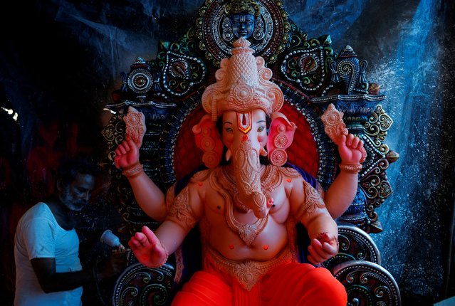 A man works on an idol of the Hindu god Ganesh, the deity of prosperity, ahead of the Ganesh Chaturthi festival, at his workshop in Ahmedabad, India on September 4, 2024. (Photo by Amit Dave/Reuters)