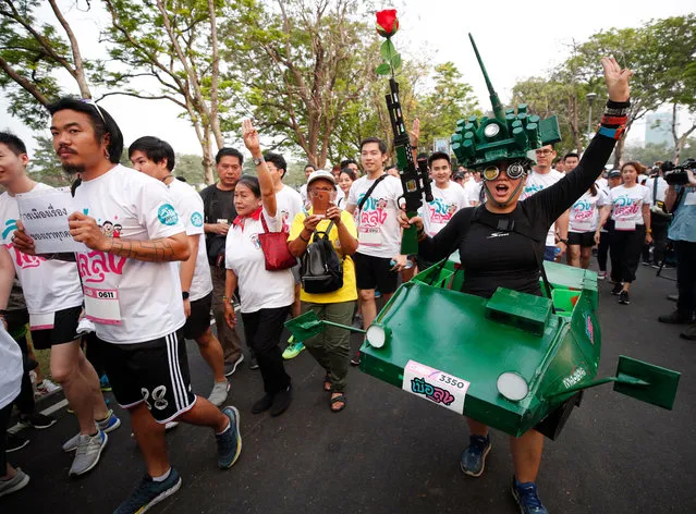 A Thai anti-government runner dressed up in a costume depicting a military tank holds a toy gun while flashing a three-finger salute during the “Run Against Dictatorship”, a political rally event at a public park in Bangkok, Thailand, 12 January 2020. Thousands of people took part in the morning jog anti-government rally event “Run Against Dictatorship” dubbed in Thai as “Run to Oust Uncle”, a subtle reference to Thai Prime Minister Prayut Chan-o-cha, while a rival group held the “Walk to Cheer Uncle” to support the government. (Photo by Rungroj Yongrit/EPA/EFE)
