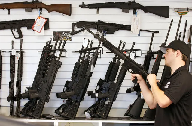 Salesman Ryan Martinez clears the chamber of an AR-15 at the “Ready Gunner” gun store in Provo, Utah, U.S., June 21, 2016. (Photo by George Frey/Reuters)