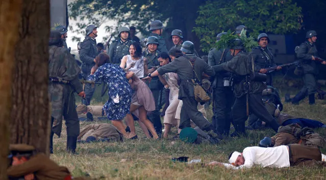Military enthusiasts dressed as Nazi troops and Soviet Red Army and civilians take part in a re-enactment of a World War II battle at the Hero fortress as they mark the 75th anniversary of the Nazi Germany invasion, in Brest, Belarus June 22, 2016. (Photo by Vasily Fedosenko/Reuters)