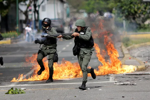 A riot security force member aims his weapon at a rally during a strike called to protest against Venezuelan President Nicolas Maduro's government in Caracas, Venezuela, July 27, 2017. (Photo by Ueslei Marcelino/Reuters)