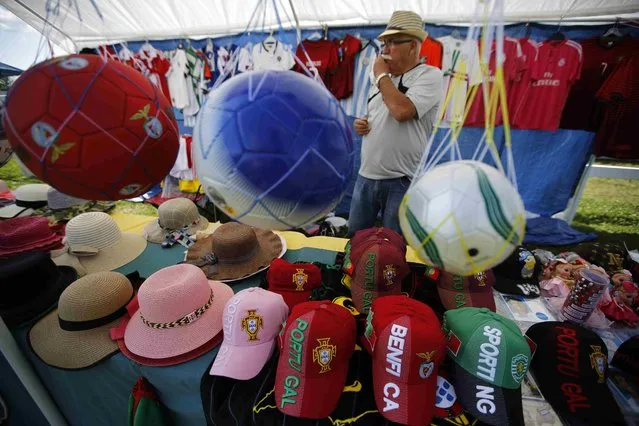 Anton Parreira awaits customers to his booth displaying Portuguese soccer balls and clothing during the intermission at an Azorean “tourada a corda” (bullfight by rope) in Brampton, Ontario August 15, 2015. (Photo by Chris Helgren/Reuters)