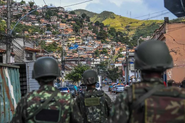 Soldiers take part in a crackdown on crime gangs, at the Lins de Vasconcelos slum complex in Rio de Janeiro, Brazil, on August 5, 2017. Thousands of Brazilian army troops raided Rio de Janeiro slums leaving parts of the city looking like a war zone. Their main goal was to stop gangs behind a surge in brazen robberies of commercial trucks, with arrest warrants issued for 40 people. However, the unusually aggressive pre-dawn operation also follows wider concerns that nearly bankrupt post-Olympic Rio is spinning out of control. (Photo by Apu Gomes/AFP Photo)