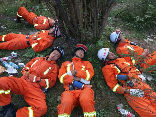 Chinese paramilitary police sleep on the ground after an 18- hour rescue operation in Jiuzhaigou in China' s southwestern Sichuan province on August 9, 2017. China on August 9 evacuated tens of thousands people in its mountainous southwest after a strong earthquake killed at least 19 people and rattled a region where memories of a 2008 seismic disaster remain fresh. (Photo by AFP Photo/Stringer)