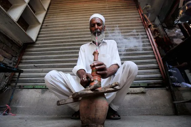 A man smokes huqqa a day ahead of World No Tobacco Day, in Peshawar, Pakistan, 30 May 2022. The World No Tobacco Day will be observed on 31 May across the world to emphasize all the risks associated with tobacco and stand for effective policies to reduce its consumption. The theme of World No Tobacco Day 2022 is “Protect the environment”. (Photo by Bilawal Arbab/EPA/EFE)