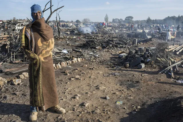 Residents of the Plastic View informal settlement collects usable household goods after a huge fire destroyed over 200 homes in the slum area, east of the South African city Pretoria on July 03, 2016. Five people died early on Sunday due to the fire and at least 1200 people have been rendered homeless. (Photo by Ihsaan Haffejee/Anadolu Agency/Getty Images)