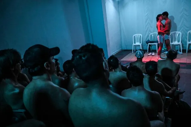 People assist a play called “A kiss from Dick”, by Colombian writer Fernando Molano, during a special nudist session at the Barraca theater in Medellin, Colombia, on July 16, 2022. (Photo by Joaquín Sarmiento/AFP Photo)