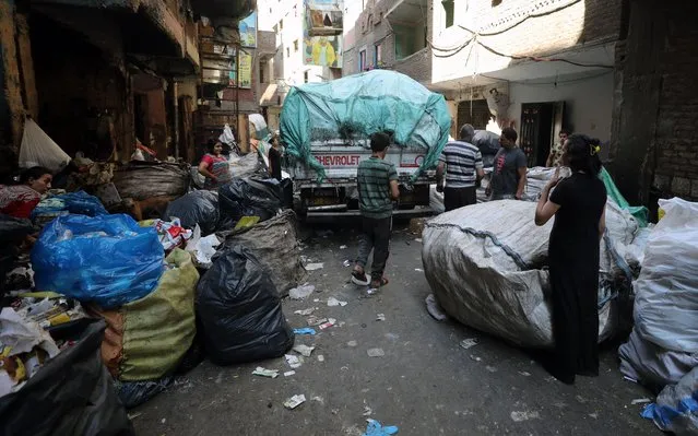 People pick up waste material for recyclables that can be re-sold in the area of Manchiyet Nasser, Mokattem, Cairo, Egypt, 27 June 2022. (Photo by Khaled Elfiqi/EPA/EFE)