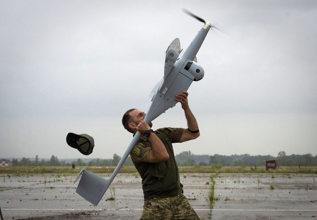 A Ukrainian soldier launches FlyEye WB Electronics SA, a Polish reconnaissance drone, which is in service with the Ukrainian army, in Kyiv region, Ukraine, Tuesday, August 2, 2022. (Photo by Efrem Lukatsky/AP Photo)
