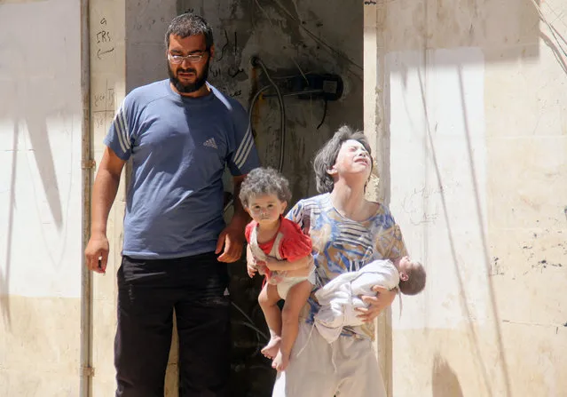 Syrian civilians are seen following a reported air strike by Syrian government forces on the rebel-held northwestern city of Idlib, on July 20, 2016. More than 280,000 people have been killed and millions displaced since Syria's civil war erupted with the brutal repression of anti-government protests in 2011. (Photo by Omar Haj Kadour/AFP Photo)