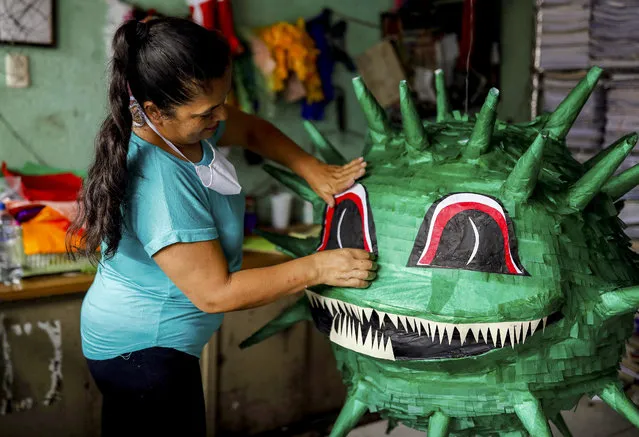 Artisan Claudia de Paz works on a pinata depicting the coronavirus at her workshop, as the spread of the coronavirus disease (COVID-19) continues, in Guatemala City, Guatemala on April 10, 2020. (Photo by Luis Echeverria/Reuters)