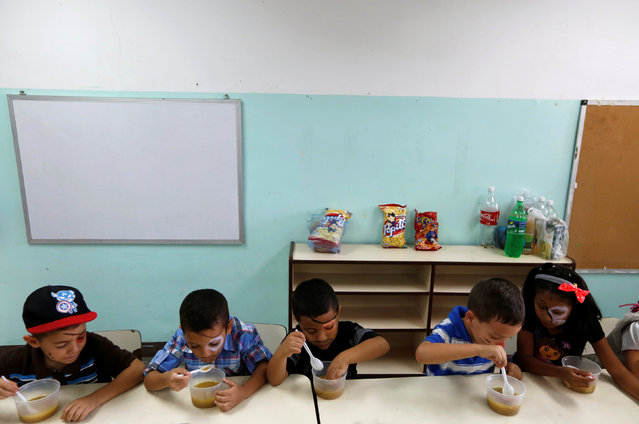 Students enjoy the soup cooked for them during an activity for the end of the school year at the Padre Jose Maria Velaz school in Caracas, Venezuela July 12, 2016. (Photo by Carlos Jasso/Reuters)