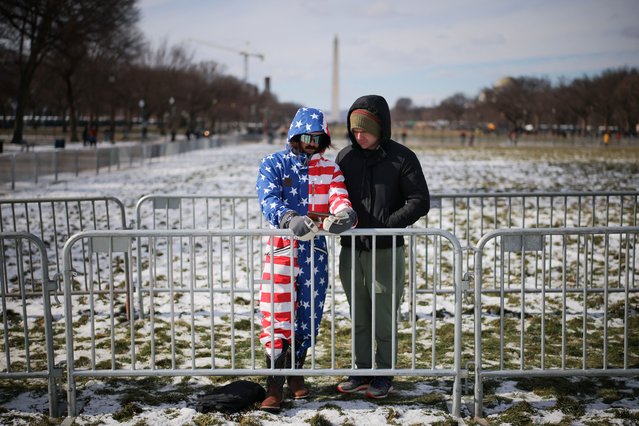 People watch coverage of the inauguration ceremony at the National Mall in Washington on January 20, 2025. (Photo by Daniel Cole/Reuters)