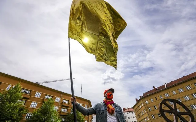 A protester waves a flag during a left-wing demonstration at Rosa-Luxemburg-Platz in Berlin, Germany, 23 May 2020. A series of demonstrations throughout the German capital, calling for ending of the social and economical restrictions imposed due to the coronavirus pandemic. The events are organized by groups of various motives, right wing activists, conspiracy theory believers and more, several counter demonstrations by left leaning organisations were also taking place. (Photo by Omer Messinger/EPA/EFE/Rex Features/Shutterstock)