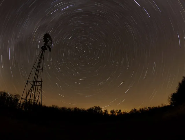 In this November 7, 2010 file photo, a windmill is silhouetted against a starry sky during a time exposure in a field near Randolph, Kan. Scientists reported Thursday, November 6, 2014, that as many as half of all stars may lie outside galaxies. (Photo by Charlie Riedel/AP Photo)