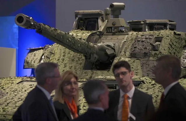 A group of salespeople speak in front of an armoured vehicle at the Defence and Security Equipment International trade show in London, Britain September 16, 2015. (Photo by Neil Hall/Reuters)
