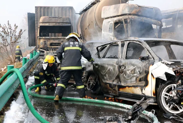 Firefighters work to put out fires in vehicles after a highway accident in Fuyang in central China's Anhui province, Wednesday, November 15, 2017. Chinese state media said about 20 people were killed after more than 30 vehicles crashed into one another on an expressway in eastern China. (Photo by Chinatopix via AP Photo)