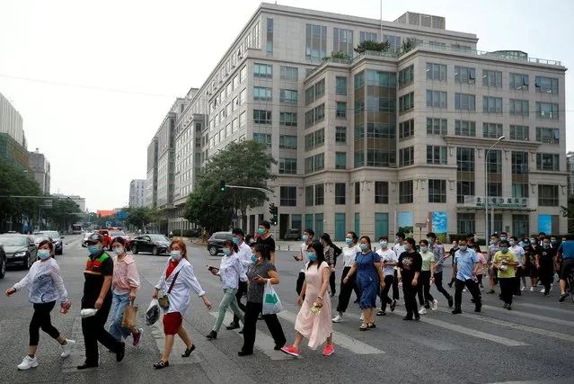 People walk to go into a makeshift testing center to receive nucleic acid tests after a new outbreak of the coronavirus disease (COVID-19) in Beijing, China, June 18, 2020. (Photo by Thomas Peter/Reuters)