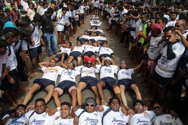 Indian devotees form a horizontal human pyramid on the ground to celebrate Dahi Handi with protest, shows black flags on occasion of the Janmashtami Festival in Mumbai, India, 25 August 2016.According to reports, the Supreme Court banned minors to participate in forming human pyramids and ordered to limit the height of human pyramids to 20 feet. The festival celebrates the birth of the Hindu god Lord Krishna, one of the most popular gods in Hinduism. (Photo by Divyakant Solanki/EPA)