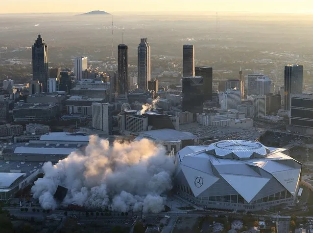 The Georgia Dome is destroyed in a scheduled implosion next to its replacement the Mercedes-Benz Stadium, right, Monday, November 20, 2017, in Atlanta. The dome was not only the former home of the Atlanta Falcons but also the site of two Super Bowls, 1996 Olympics Games events and NCAA basketball tournaments among other major events. (Photo by Curtis Compton/Atlanta Journal-Constitution via AP Photo)