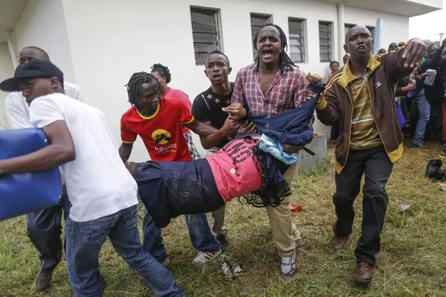 People carry an injured woman after police used tear gas to disperse crowd who tried to force their way into the stadium where President-elect Uhuru Kenyatta is about to arrive for his swearing-in ceremony in Nairobi, Kenya,  November 28, 2017. (Photo by Dai Kurokawa/EPA/EFE/Rex Features/Shutterstock)