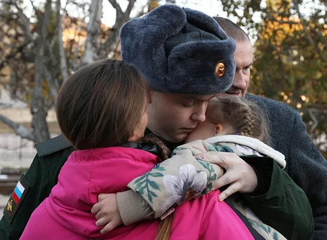 A conscript says goodbye to family members at a local railway station during departure for the garrisons, in Sevastopol, Crimea on November 9, 2022. (Photo by Alexey Pavlishak/Reuters)