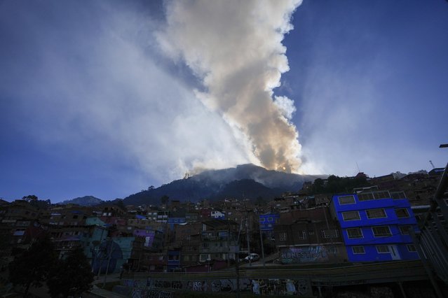 The sun rises during a forest fire on El Cable Hill in Bogota, Colombia, Thursday, January 25, 2024. (Photo by Fernando Vergara/AP Photo)