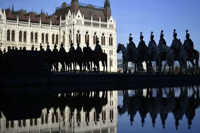 Hungarian honour guards attend the official flag raising ceremony for the 66th anniversary of Hungarian anti-communist uprising of 1956 in front of the Parliament in Budapest, Hungary, Sunday, October 23, 2022. (Photo by Anna Szilagyi/AP Photo)