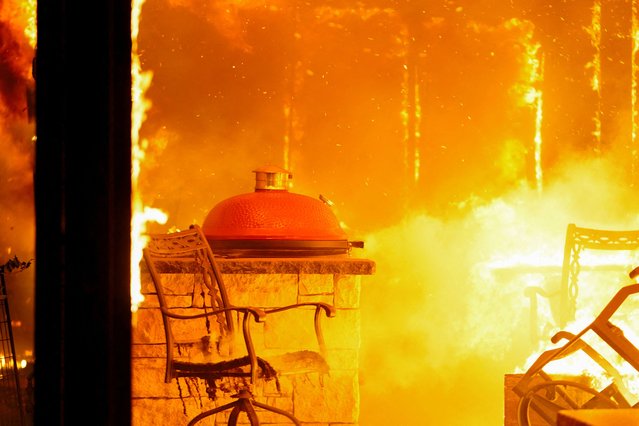 Fire burns a residence during a wildfire outbreak in Stillwater, Oklahoma, on March 14, 2025. (Photo by Nick Oxford/Reuters)