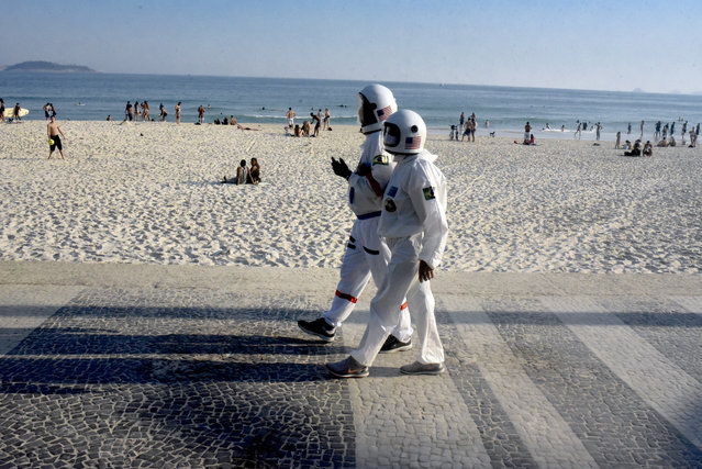 People dressed as astronauts are seen amid coronavirus (Covid-19) pandemic along Ipanema beach in the south zone of Rio de Janeiro, Brazil on July 21, 2020. The outfit even has the NASA symbol and was created for trips around the city and the beach. Elderly with a chronic lung problem, retired accountant Tercio Galdino Lima, 66, decided to make the overalls and helmet for himself and his wife Alicea Lima, 65, to be able to walk more safely on the streets of Rio and reduce the risk of contagion by the coronavirus. Brazil has an average of 1,048 deaths per day from coronavirus in the last week. (Photo by Fabio Teixeira/Anadolu Agency via Getty Images)