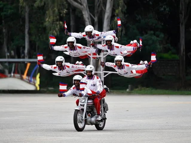 Members of Shwet Ashw, the motorcycle display team of the Indian army, performs during the platinum jubilee celebrations of Corps of Military Police in Bangalore, India, Monday, October 20, 2014. (Photo by Aijaz Rahi/AP Photo)