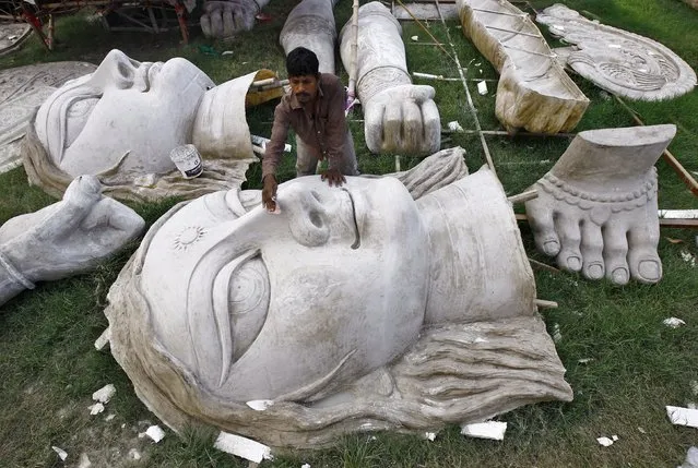 An artisan sandpapers an idol of the Hindu goddess Durga before applying paint on it ahead of the Durga Puja festival in Kolkata, India, September 30, 2015. The Durga Puja festival will be celebrated from October 19 to 22, which is the biggest religious event for Bengali Hindus. Hindus believe that the goddess Durga symbolises power and the triumph of good over evil. (Photo by Rupak De Chowdhuri/Reuters)