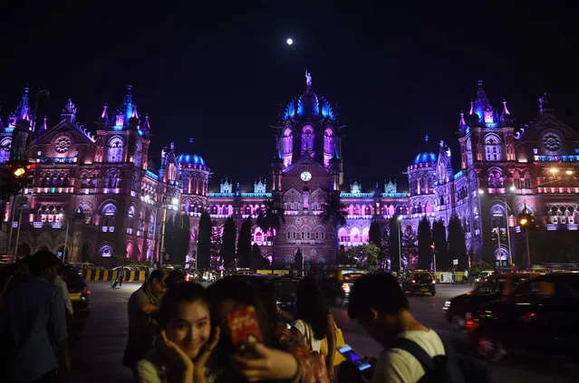 Indians take pictures in front of the lit up Chattrapathi Shivaji Terminus (CST) railway station ahead of New Year' s eve celebrations in Mumbai on December 31, 2017. (Photo by Punit Paranjpe/AFP Photo)