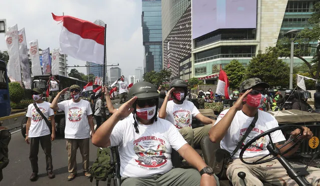 Participants salute during the 75th Independence Day commemoration in Jakarta, Indonesia, Monday, August 17, 2020. Indonesia gained its independence in 1945 from the Dutch colonial rule. (Photo by Achmad Ibrahim/AP Photo)