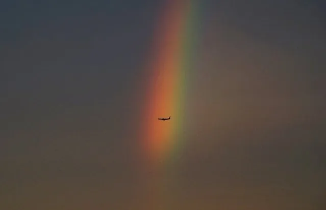 An airplane flies past a rainbow at dusk in Beijing, China, August 3, 2015. (Photo by Reuters/Stringer)