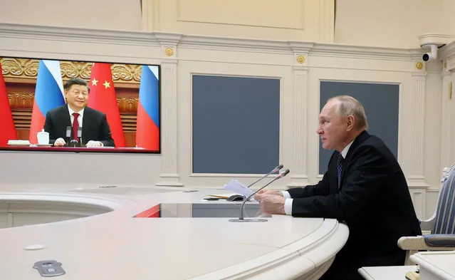 Russian President Vladimir Putin holds a meeting with Chinese President Xi Jinping via a video link at the Kremlin in Moscow on December 30, 2022. Russian leader told his Chinese counterpart on December 30 he was keen to ramp up military cooperation and hailed the two countries' efforts to counter Western influence. (Photo by Mikhail Klimentyev/Sputnik via AFP Photo)