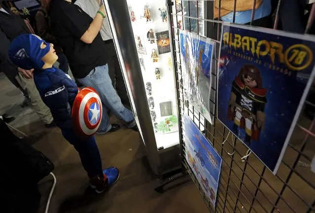 A young participant dressed as superhero Captain America looks at figurines during the first edition of the HeroFestival in Marseille, November 9, 2014. (Photo by Jean-Paul Pelissier/Reuters)