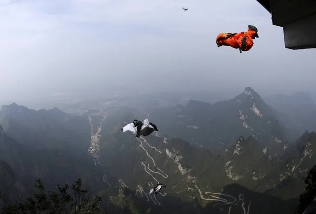 Wingsuit flyer contestants jump off a mountain during the fourth World Wingsuit Flying Tournamentat at the Tianmen Mountain National Park in Zhangjiajie, Hunan province, China, October 18, 2015. (Photo by Reuters/China Daily)